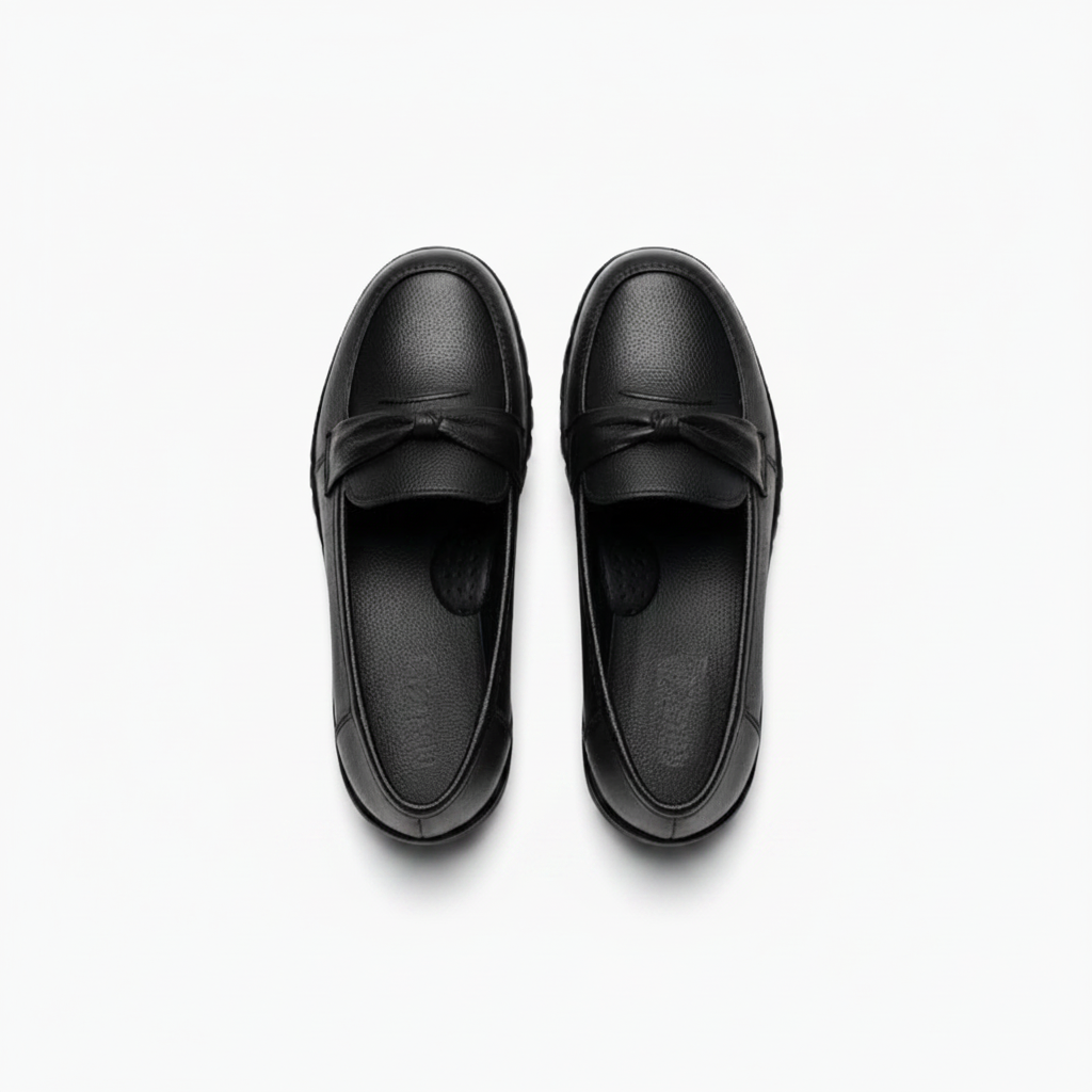 Vue de l'arrière d'un mocassin compensé noir, accentuant la forme ergonomique du talon et sa robustesse.