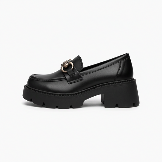 Détail de la chaînette argentée délicatement posée sur le devant du mocassin noir femme, apportant une touche raffinée.