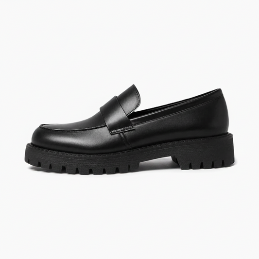 Profil élégant d'un mocassin plateforme noir montrant la semelle crantée et la hauteur discrète de la plateforme.