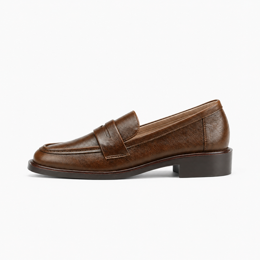 Mocassin marron femme vue de profil - Chaussure plate en cuir grainé brun avec bride penny, couture d’apron et semelle épaisse confortable.