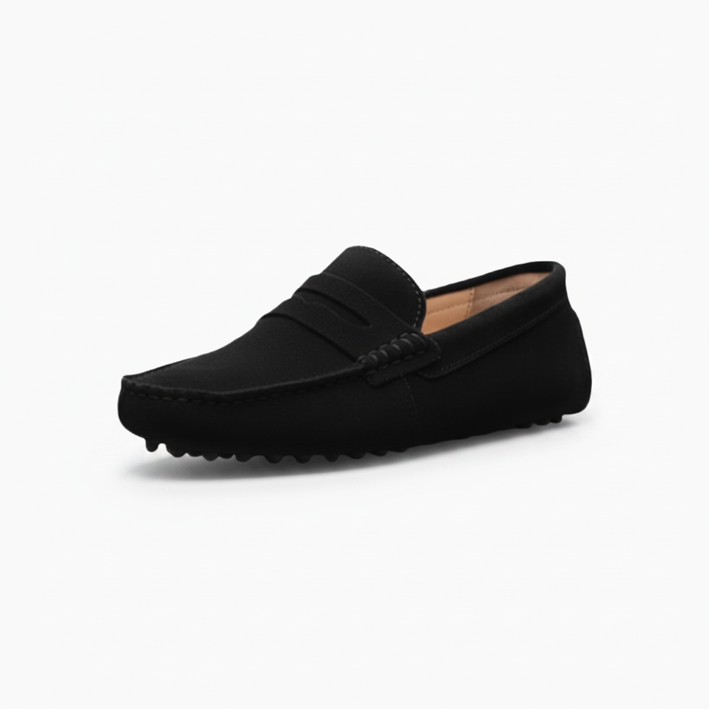 Mocassins élégants en daim noir pour femme, portés avec un pantalon de tailleur gris, idéaux pour le bureau.