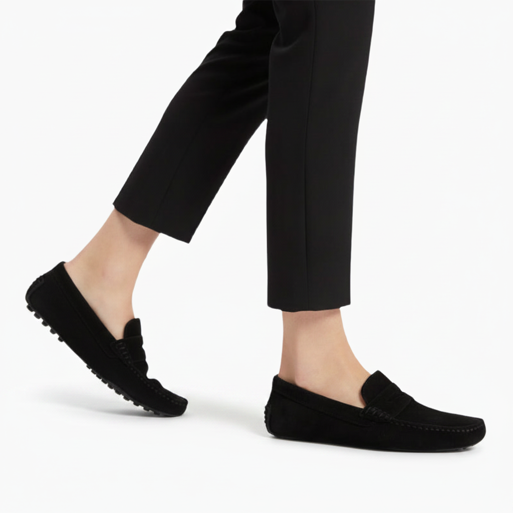 Paire de mocassins noirs sophistiqués posés sur un sol clair, mettant en valeur leur silhouette épurée et intemporelle.