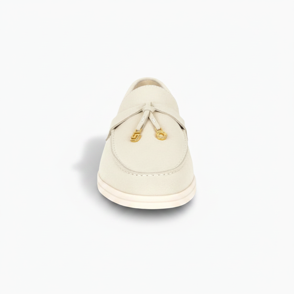 Gros plan sur les coutures délicates du mocassin en suède crème, gage de qualité artisanale.