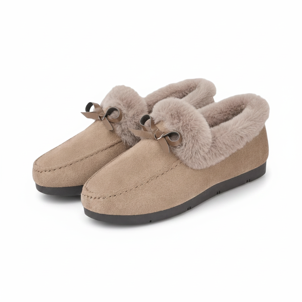 Paire de chaussons mocassins beiges pour femme, posée sur un tapis moelleux, invitant à la détente.