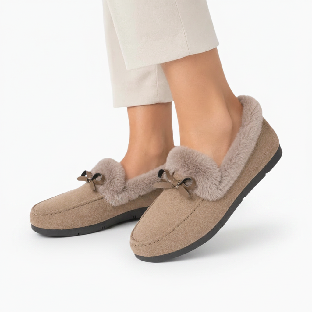 Pieds confortablement installés dans des chaussons mocassins beiges, savourant un moment de quiétude.