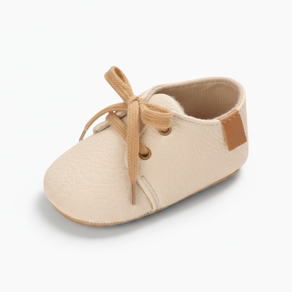Mocassin bébé beige en cuir souple avec lacets ajustables pour premiers pas.