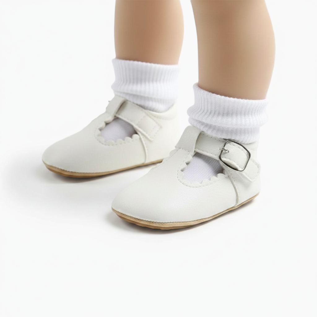 Vue de côté d'un mocassin bébé blanc, mettant en valeur sa semelle souple pour l'apprentissage de la marche.