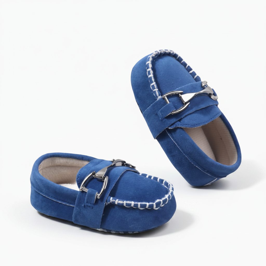 Détail de la chaînette métallique discrète ornant le dessus d'un mocassin bébé, ajoutant une touche de sophistication.