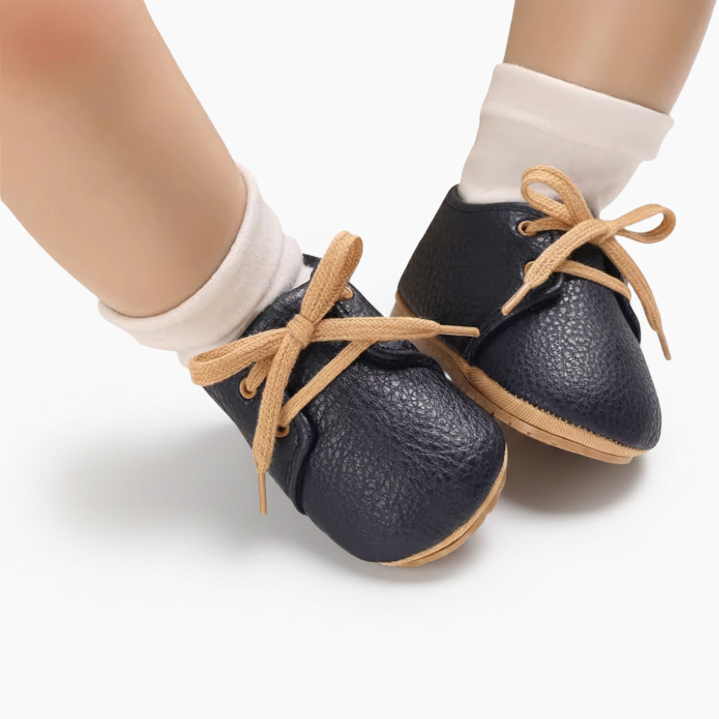 Gros plan sur la texture douce du cuir de veau bleu marine d'un mocassin bébé raffiné.