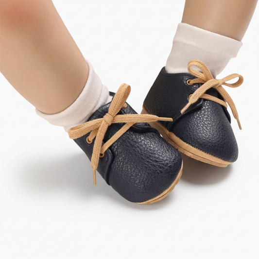 Gros plan sur la texture douce du cuir de veau bleu marine d'un mocassin bébé raffiné.