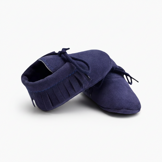 Mocassin bébé en daim bleu marine avec lacets décoratifs, parfait pour un look élégant et décontracté.