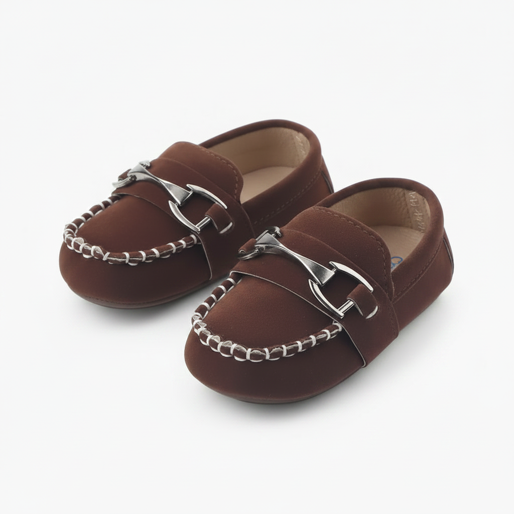 Bébé portant des mocassins en daim marron, se tenant debout et explorant ses premiers pas hésitants.