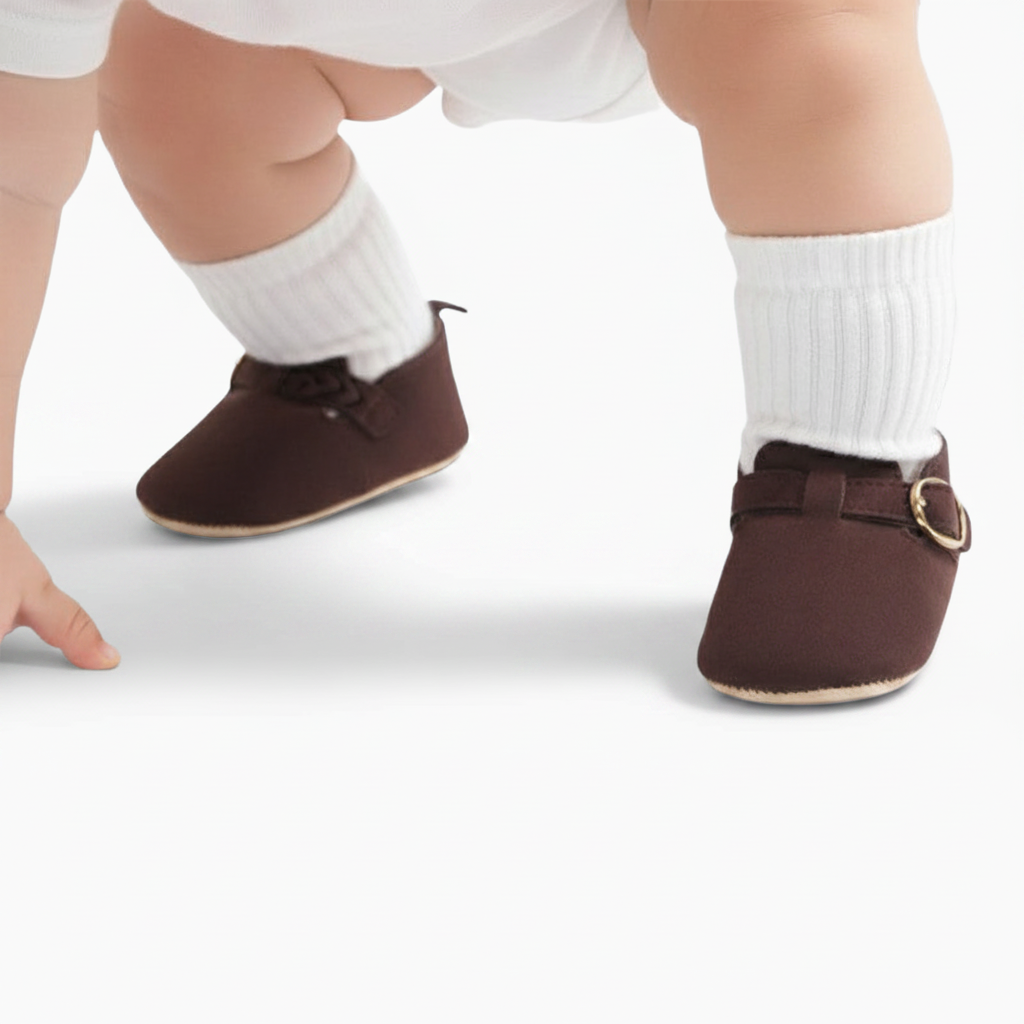 Bébé faisant ses premiers pas, porté par le confort et le style de ses mocassins marron.