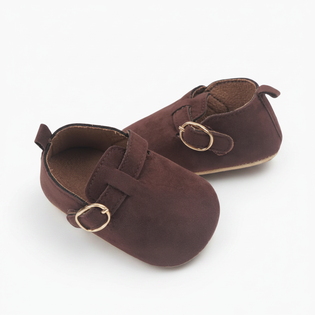 Détail du daim souple des mocassins bébé, capturant la richesse de la couleur marron.