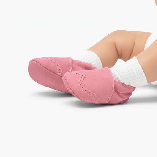 Semelle antidérapante d'un mocassin bébé rose, conçue pour les premiers pas en toute sécurité et confort.