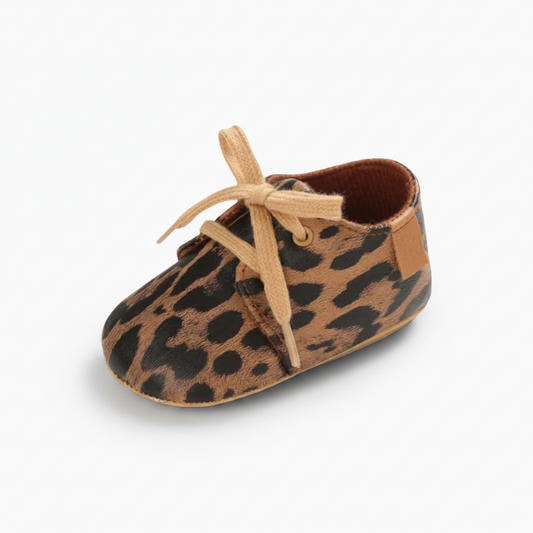 Mocassins bébé léopard en cuir souple, parfaits pour les premiers pas d'une petite fille.