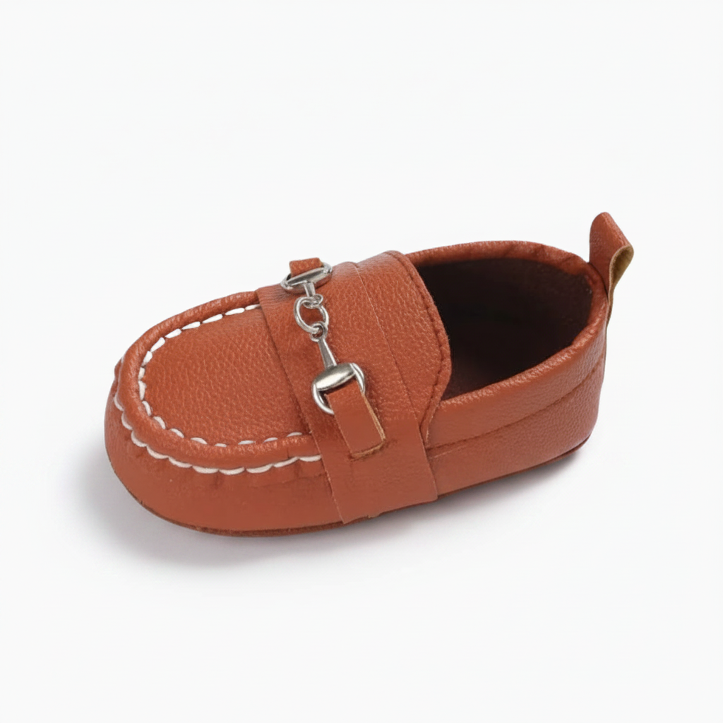 Mocassin bébé marron élégant avec chaînette dorée, parfait pour les premiers pas et l'apprentissage de la marche.
