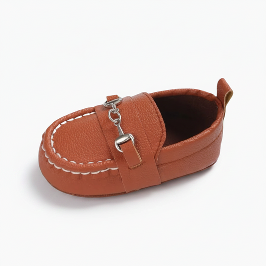 Mocassin bébé marron élégant avec chaînette dorée, parfait pour les premiers pas et l'apprentissage de la marche.