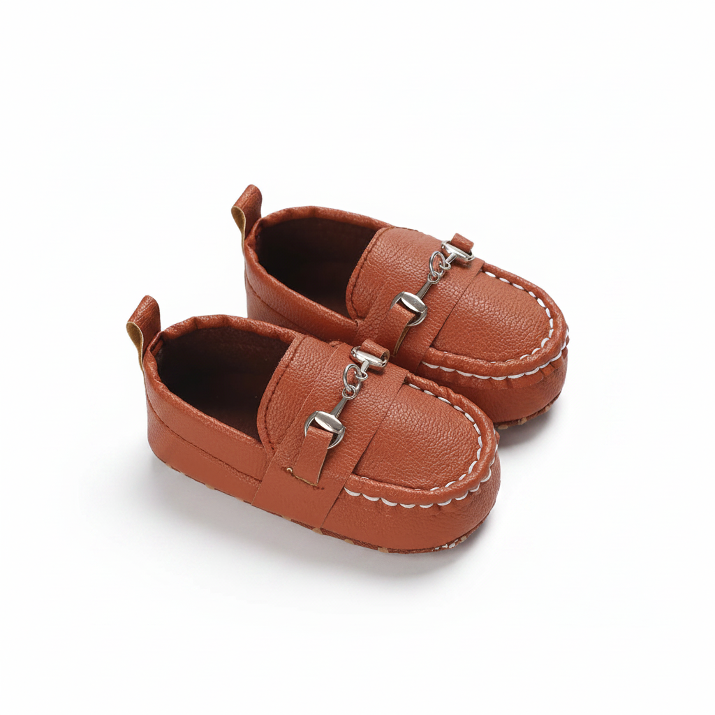 Bébé faisant ses premiers pas avec confiance, ses mocassins marron à chaînette offrant un soutien délicat et stylé.