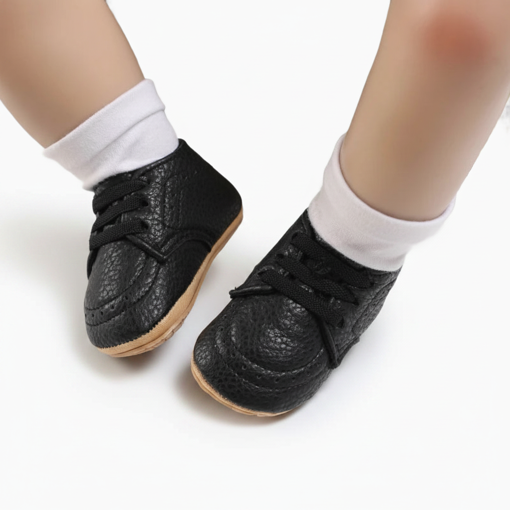 Vue détaillée du lacet ajustable et du design intemporel du mocassin bébé noir en matière souple.