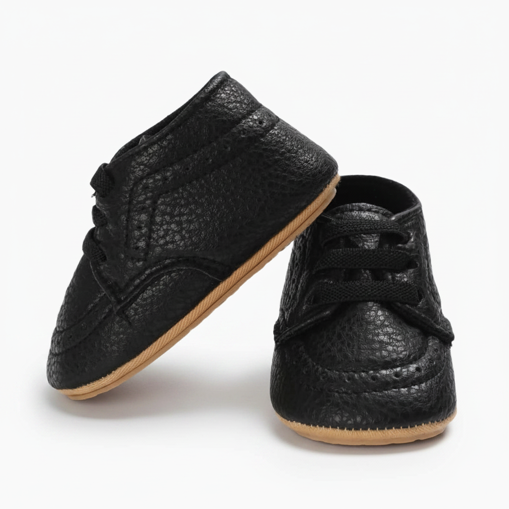 Petit pied de bébé en plein mouvement, enveloppé dans un mocassin noir chic et sécurisé par un lacet.