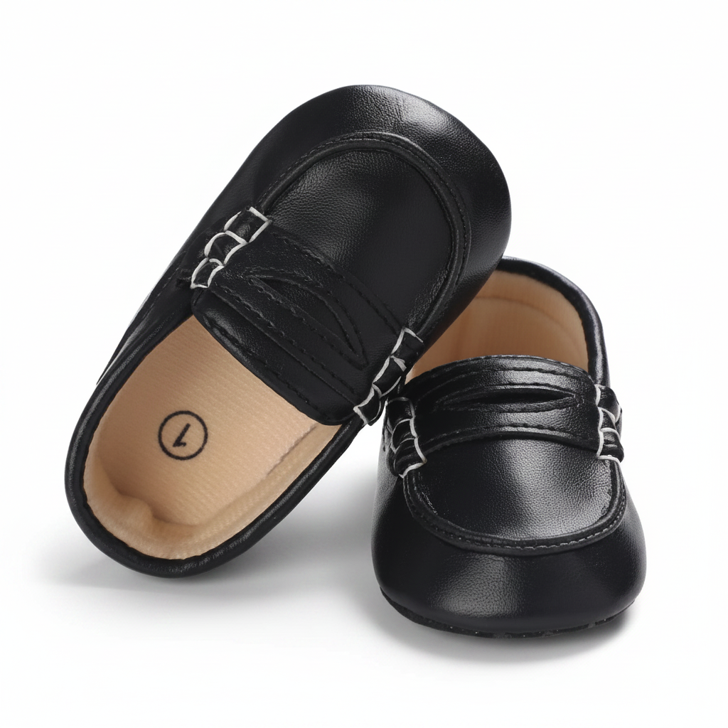 Détail raffiné des surpiqûres contrastantes sur le mocassin bébé noir en cuir.