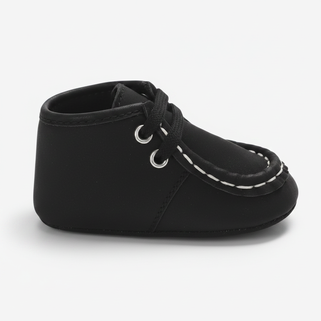 Un pied de bébé chaussé d'un chic mocassin noir en daim, prêt pour l'aventure.