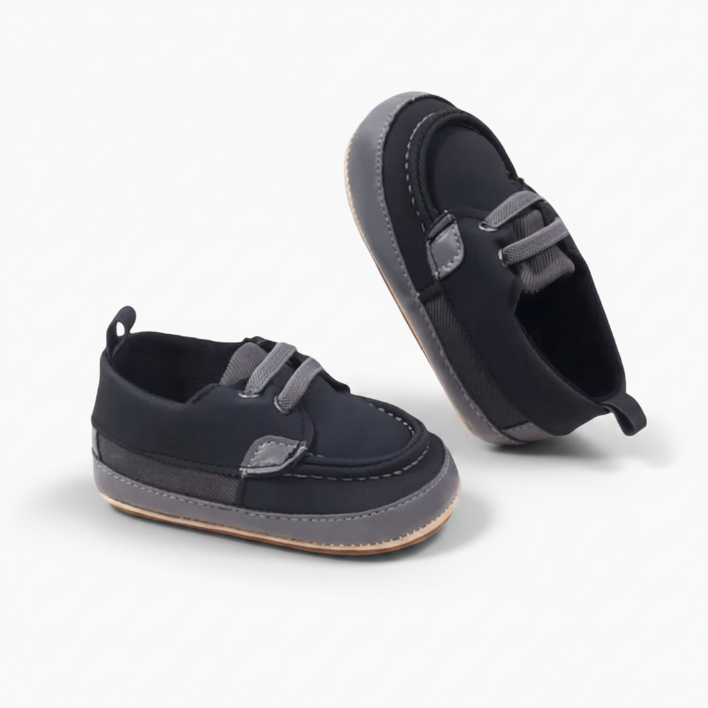 Bébé portant des mocassins noirs, explorant le monde à quatre pattes avec confort.