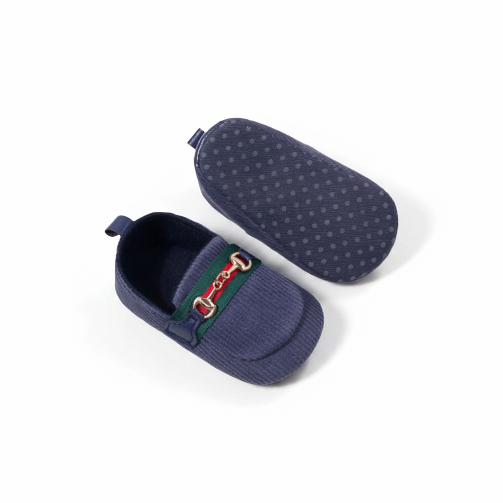 Mocassin bébé bleu marine sur une surface douce, mettant en valeur son design raffiné et intemporel.