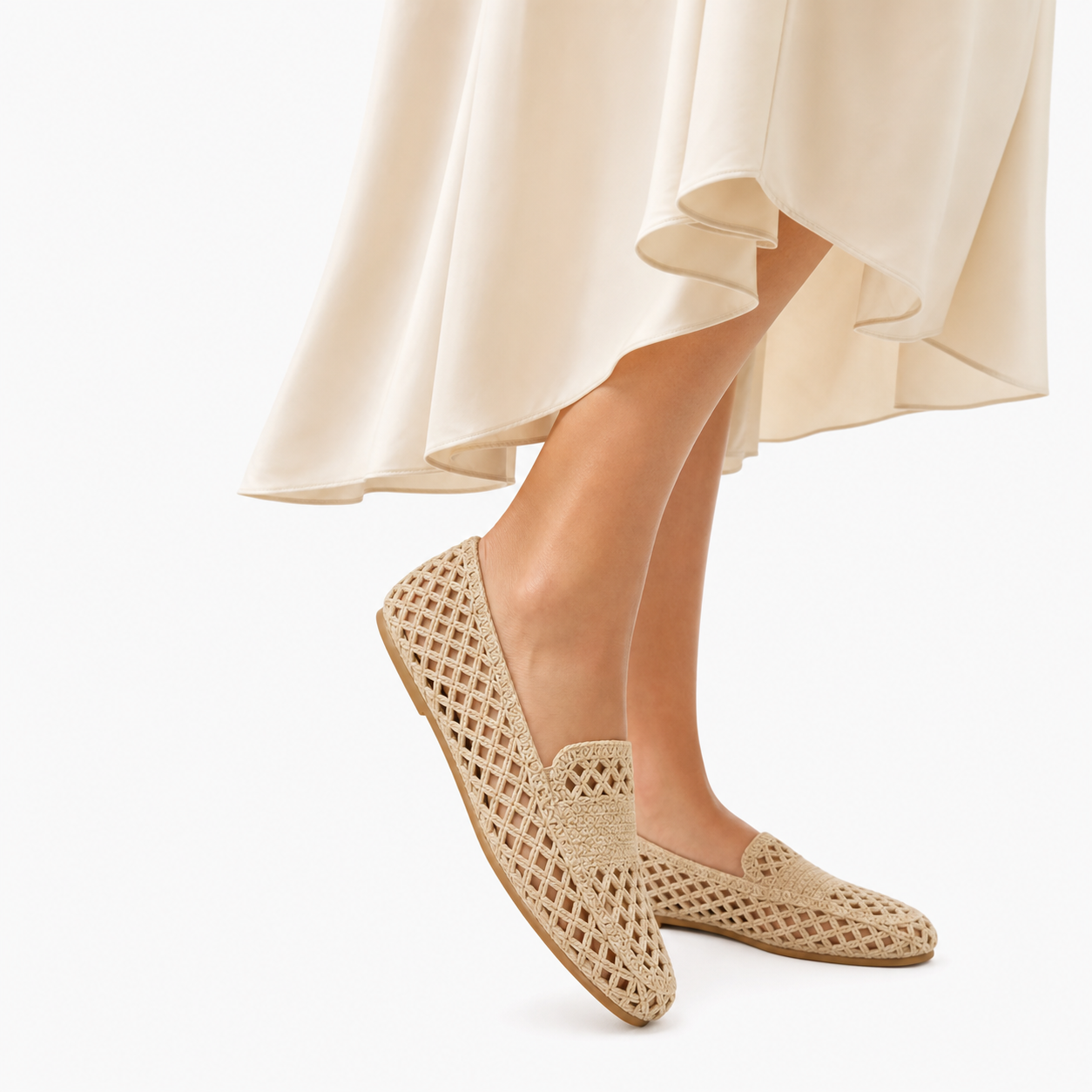 Mocassins beige ajourés femme en mouvement sous une jupe fluide — style estival élégant.