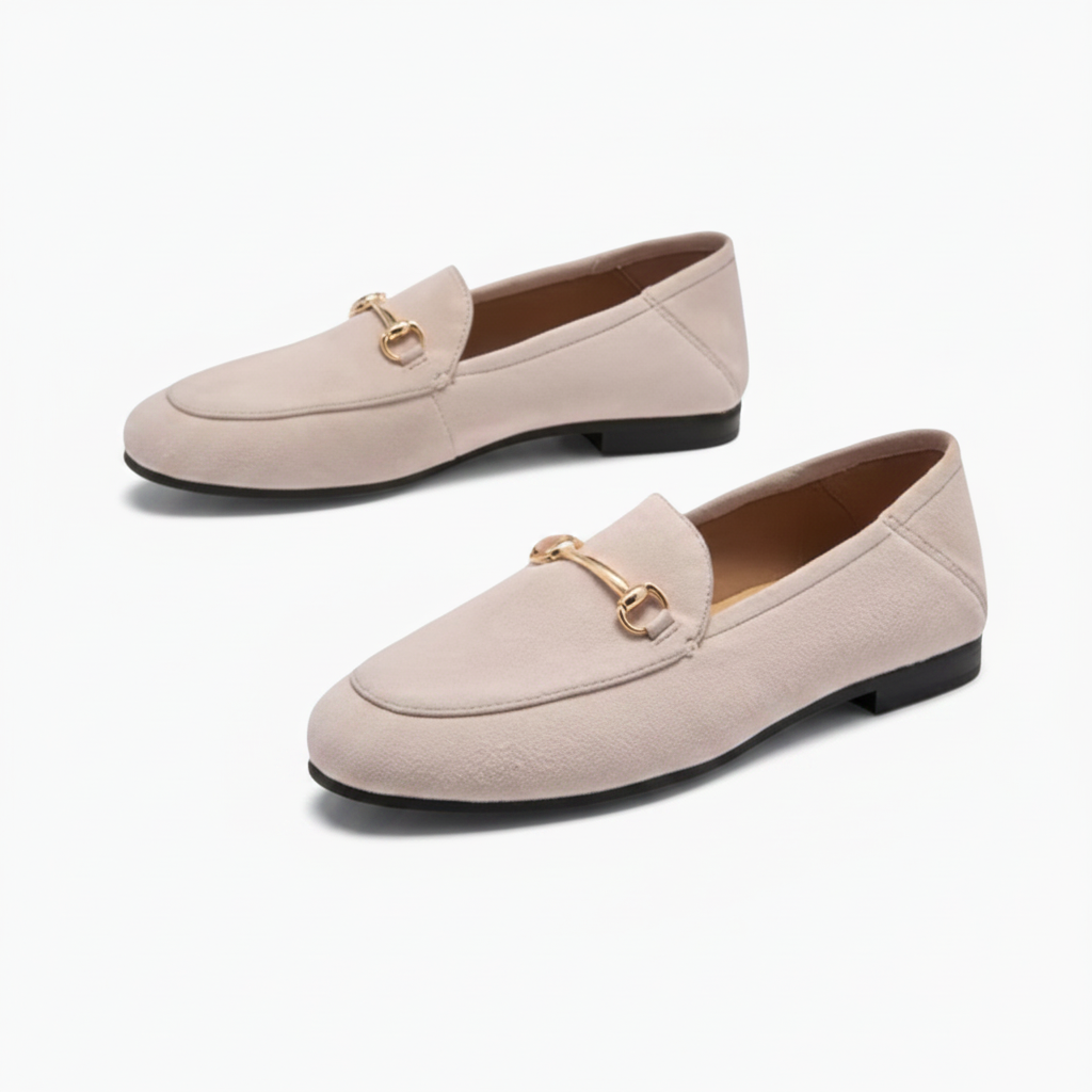 Femme moderne marchant avec aisance, portant des mocassins en daim beige polyvalents avec une tenue chic.