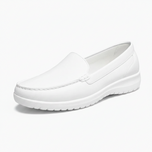 Mocassins blancs en cuir pour femme, élégamment portés avec un pantalon clair, mettant en valeur leur design épuré.