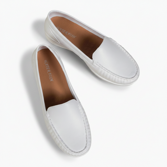 Vue latérale d'un mocassin en cuir blanc, soulignant la semelle confortable et les coutures discrètes.