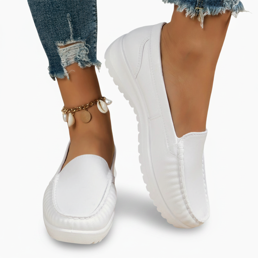 Mocassins blancs frais sur un fond neutre, prêts à compléter une tenue printanière ou estivale.