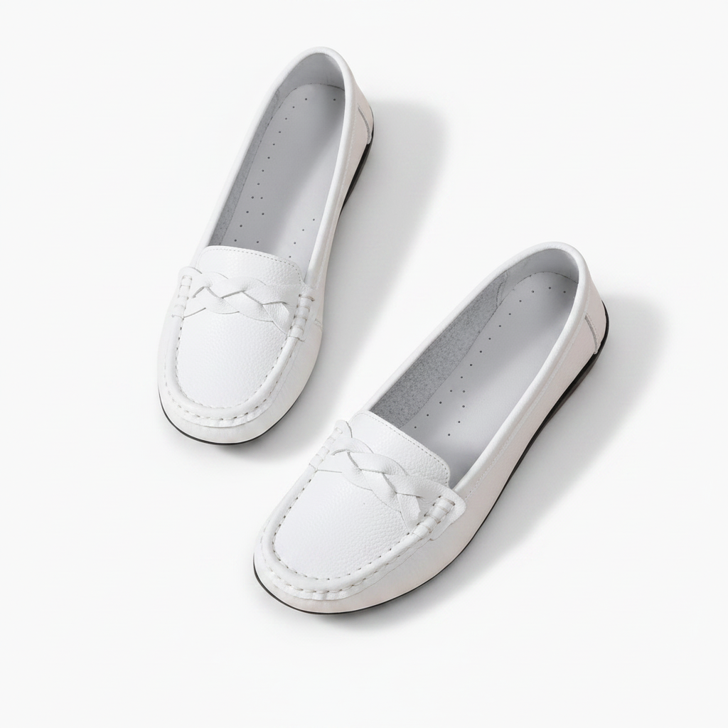 Femme portant des mocassins blancs en cuir avec un pantalon de tailleur clair, look professionnel.