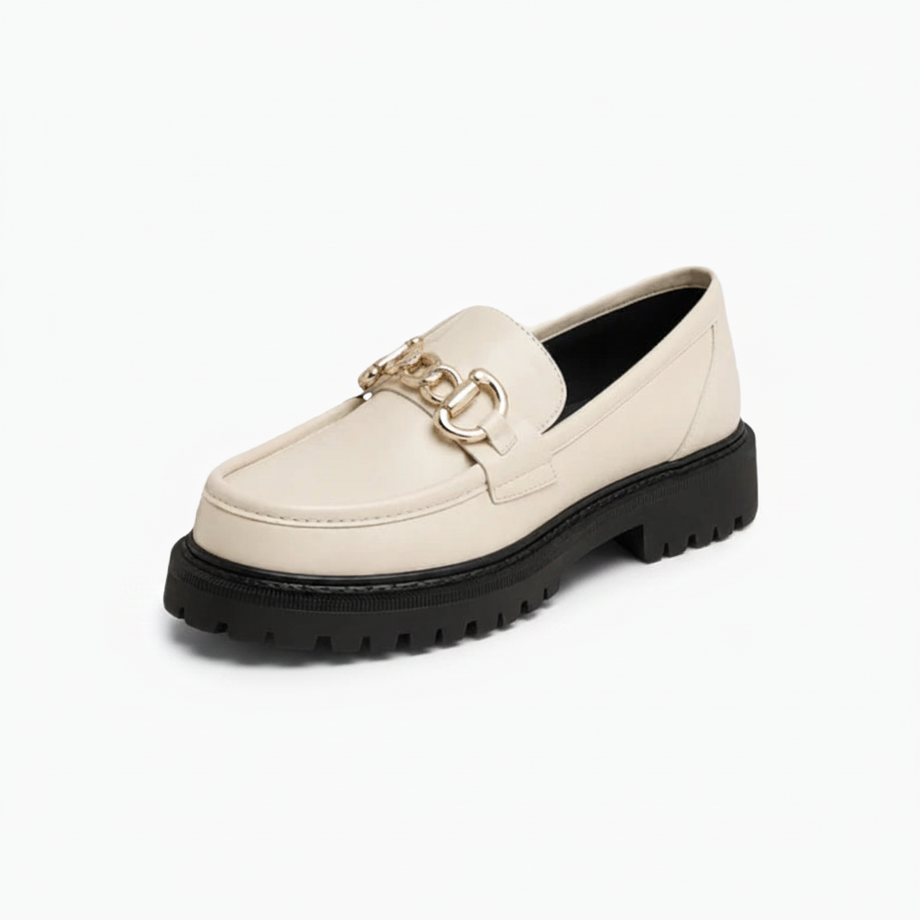 Mocassin plateforme blanc immaculé pour femme avec chaîne dorée en relief, vu de face.