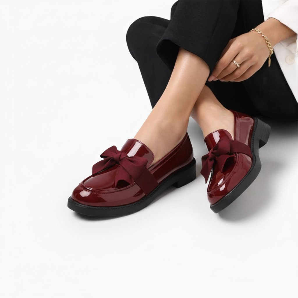 Détail des coutures fines et de la finition impeccable du mocassin en cuir vernis bordeaux.