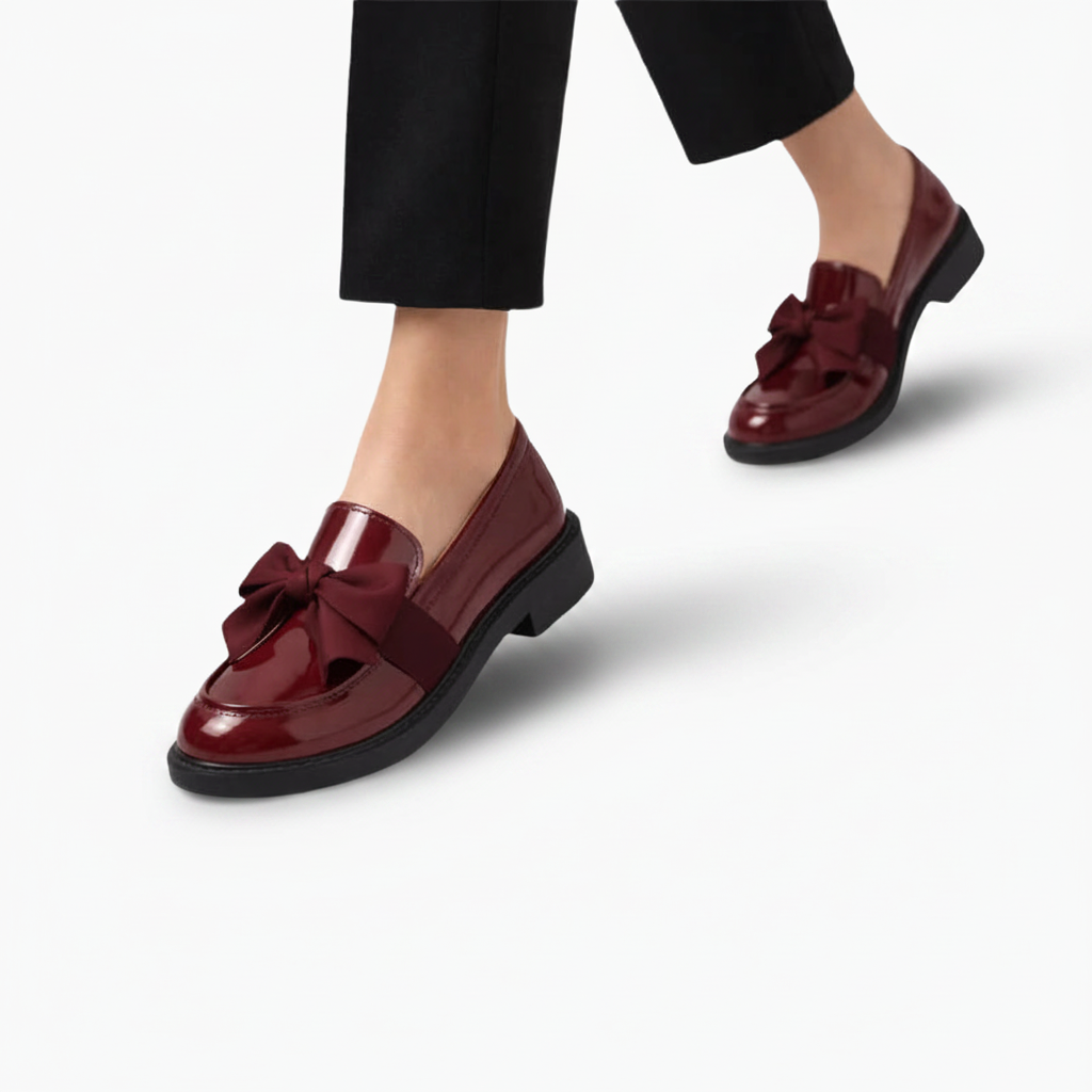 Mocassins bordeaux vernis portés avec un pantalon de costume noir, affirmant un style professionnel raffiné.
