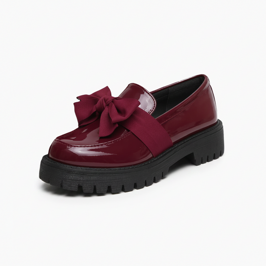 Mocassin compensé bordeaux vernis pour femme, élégant et audacieux, avec son nœud papillon distinctif.