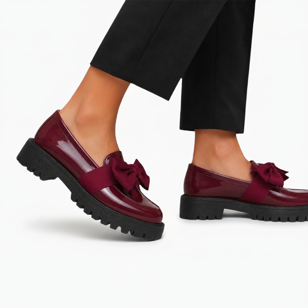 Femme en mouvement avec des mocassins bordeaux vernis à talon compensé, alliant confort et style moderne.