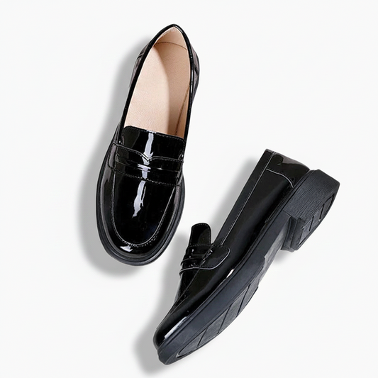 Dos du mocassin compensé en cuir noir, révélant le talon offrant confort et allure.