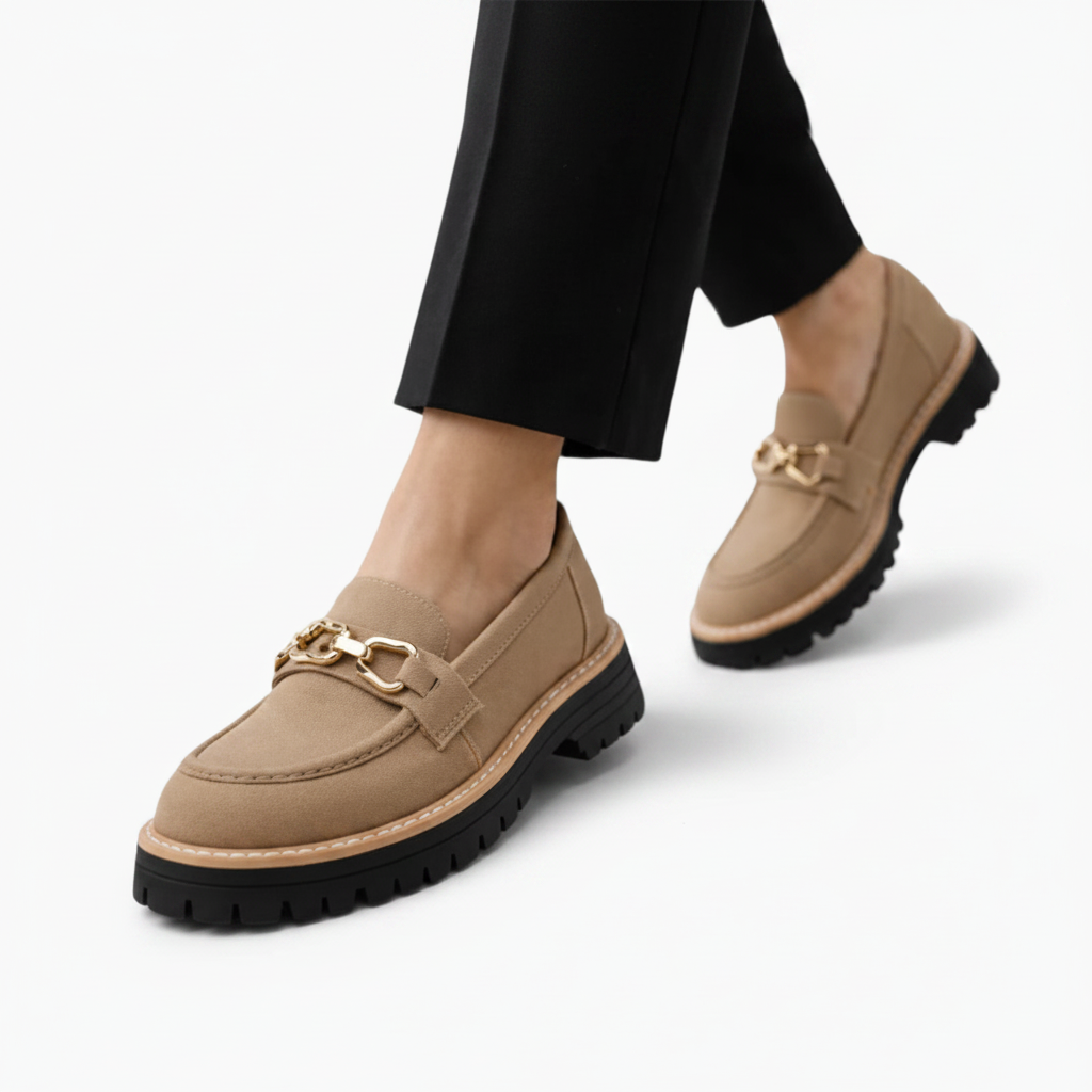 Mocassin compensé daim camel élégamment posé, reflétant la douceur de son matériau et la finesse de la chaîne.