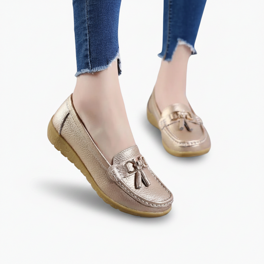 Mocassin compensé doré porté avec élégance, illuminant chaque pas d'une femme en mouvement.