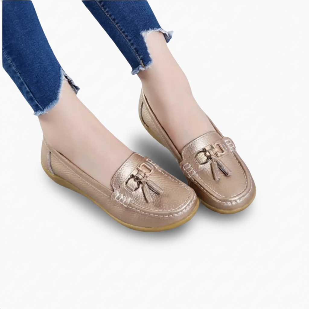 Pied féminin chaussé d'un mocassin doré, apportant une touche de sophistication à une tenue de jour.
