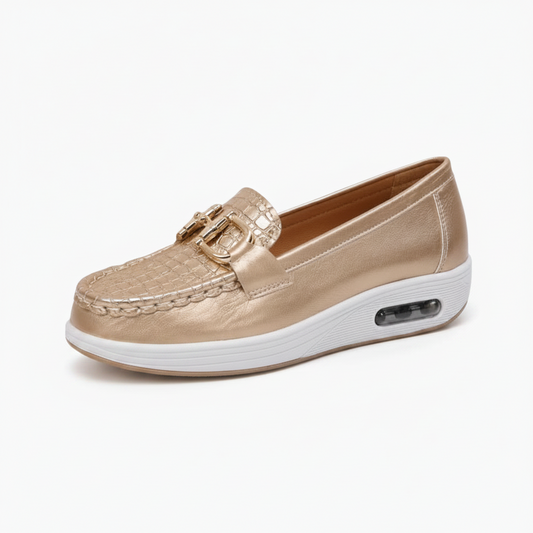 Vue latérale du mocassin doré, révélant sa semelle compensée de 4 cm et sa silhouette raffinée.