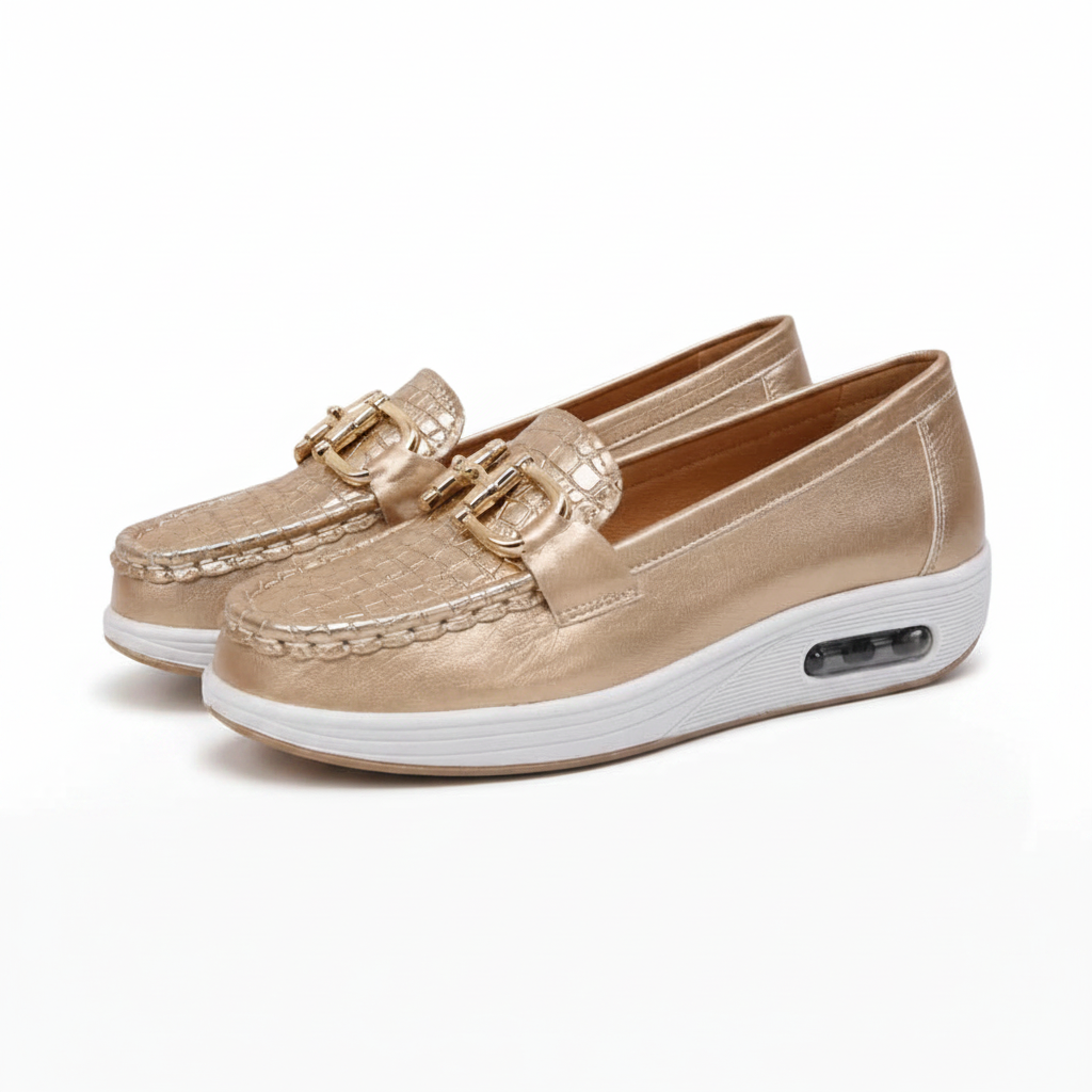 Mocassin doré posé élégamment sur une surface neutre, reflétant sa lumière et son allure chic.