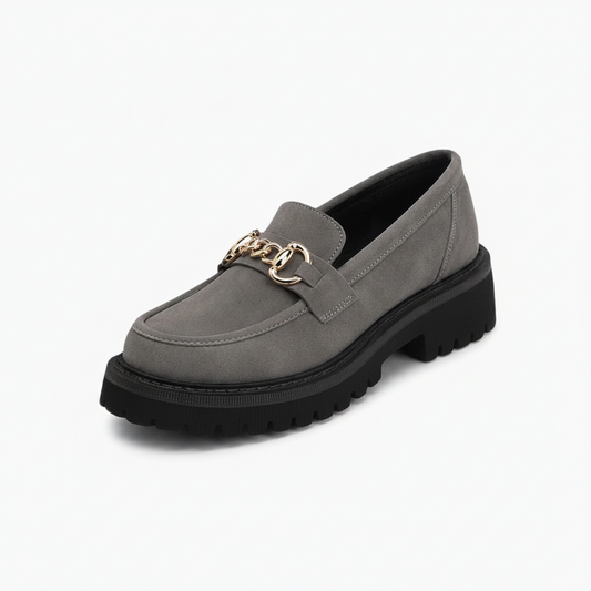 Mocassin compensé gris pour femme, affichant une allure rétro chic avec sa chaîne dorée.