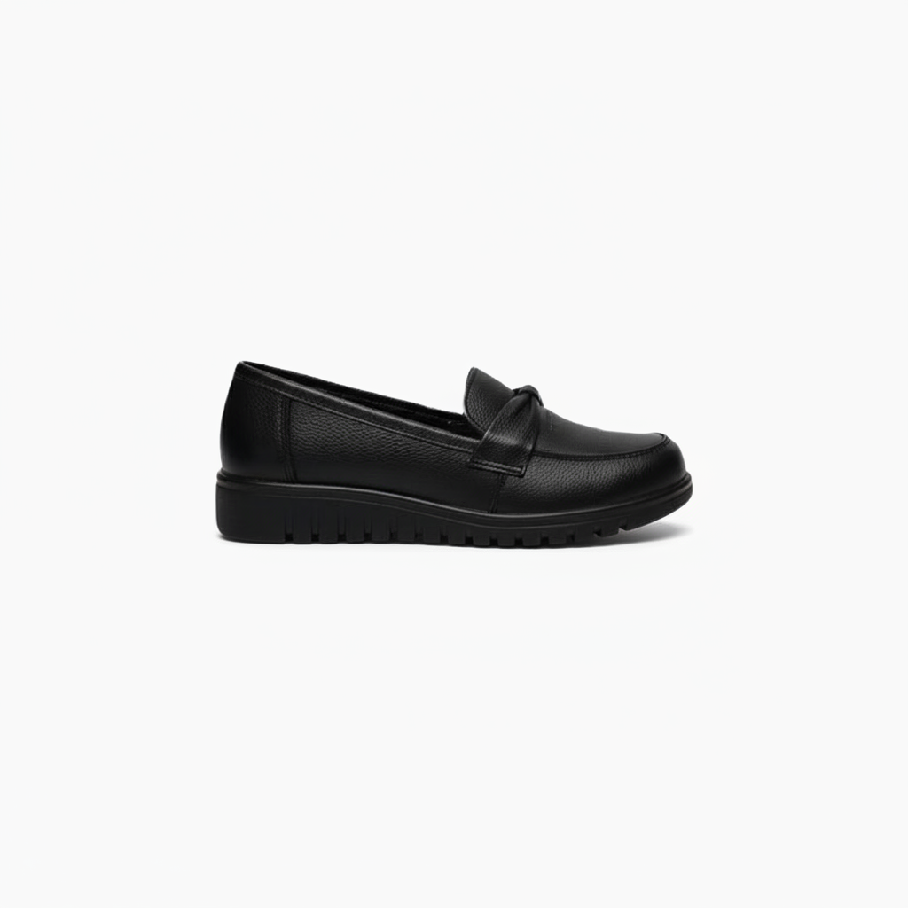 Détail du dessus d'un mocassin noir, mettant en valeur la texture du cuir lisse et le bandeau intemporel.