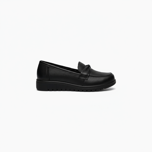 Détail du dessus d'un mocassin noir, mettant en valeur la texture du cuir lisse et le bandeau intemporel.