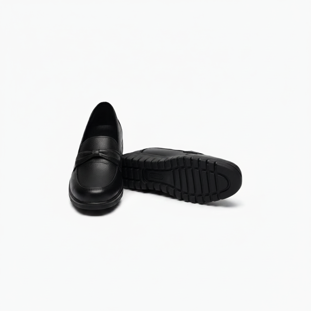 Paire de mocassins compensés noirs sur un fond épuré, symbolisant l'alliance du style moderne et du confort durable.